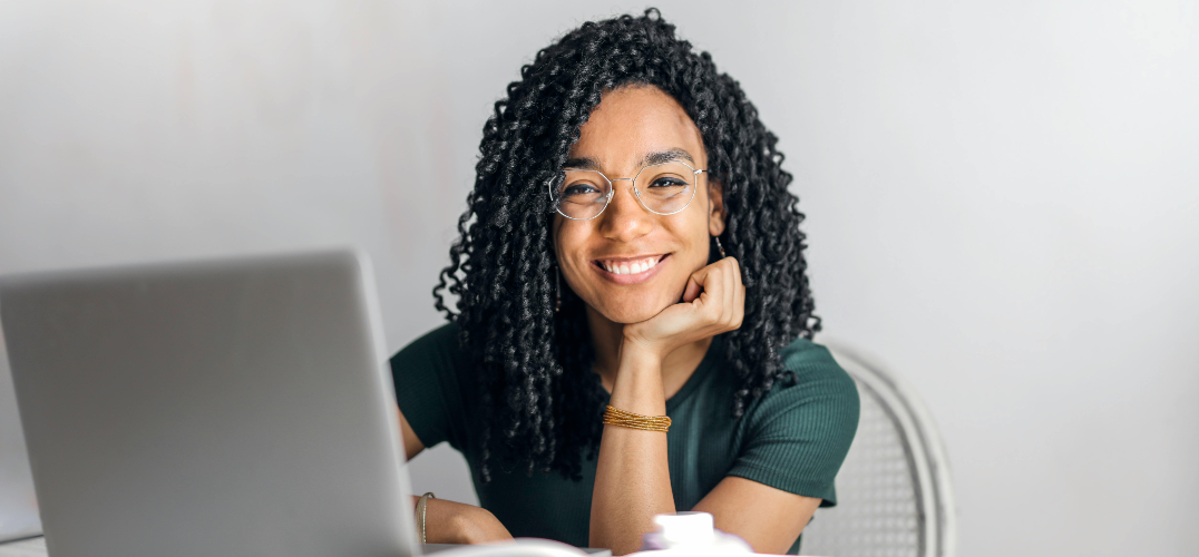 Smiling woman working on a laptop.