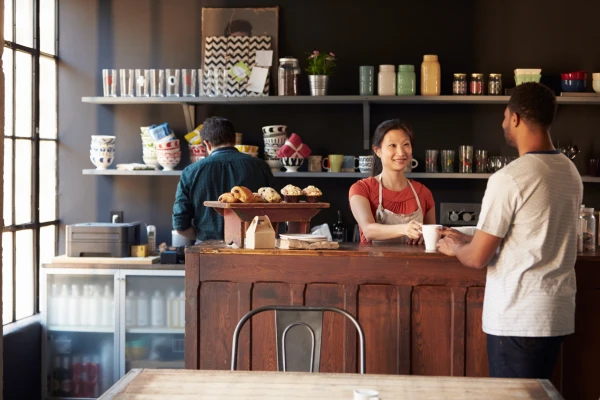 Three people around a cafe counter