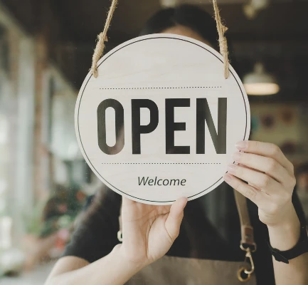 Person holding an open sign